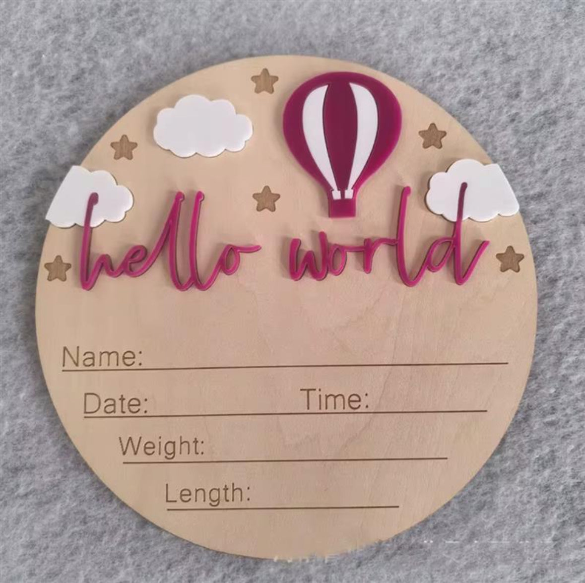 Pink hot air balloon hello world plaque – Wooden newborn announcement disc with pink acrylic hot air balloon, clouds, stars, and “hello world” text.