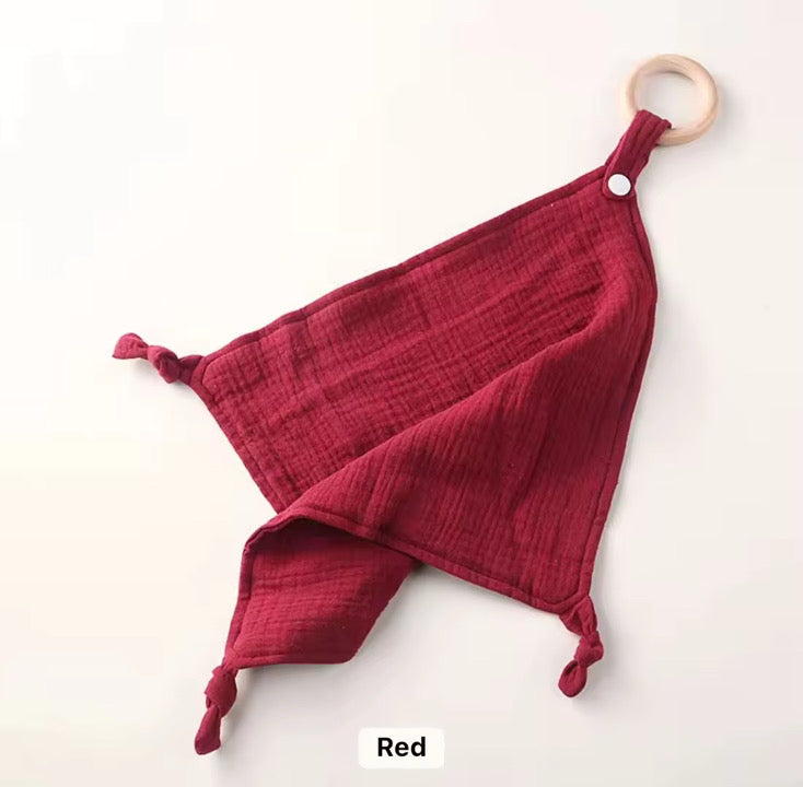 Deep red muslin comforter with wooden teether, soft and lightweight for cuddles and sensory play.
