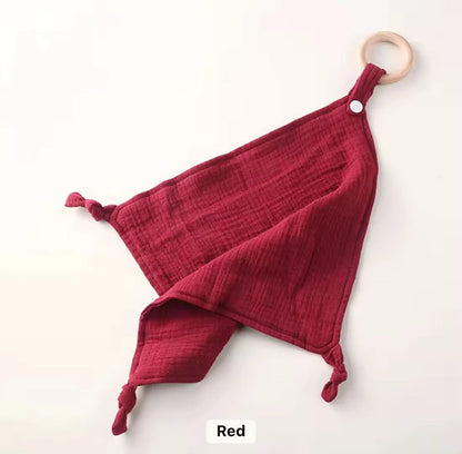 Deep red muslin comforter with wooden teether, soft and lightweight for cuddles and sensory play.