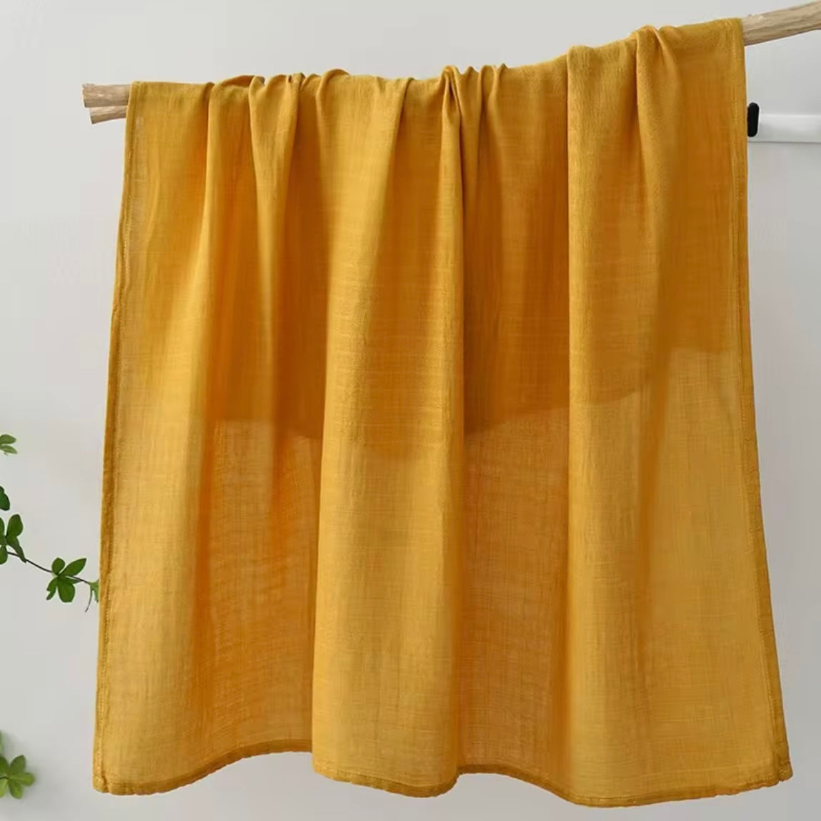 Mustard yellow muslin baby wrap, warm-toned, lightweight, and cozy for babies.