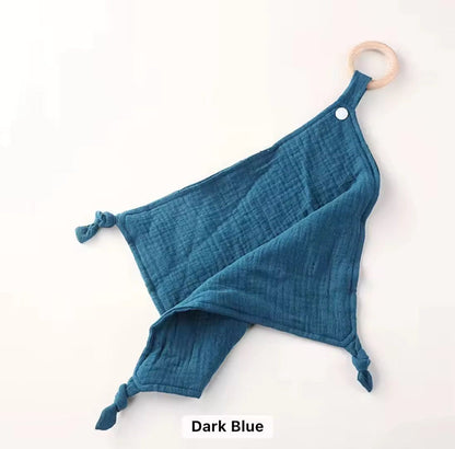 Dark blue muslin comforter with wooden teething ring, soothing and gentle on baby’s skin.