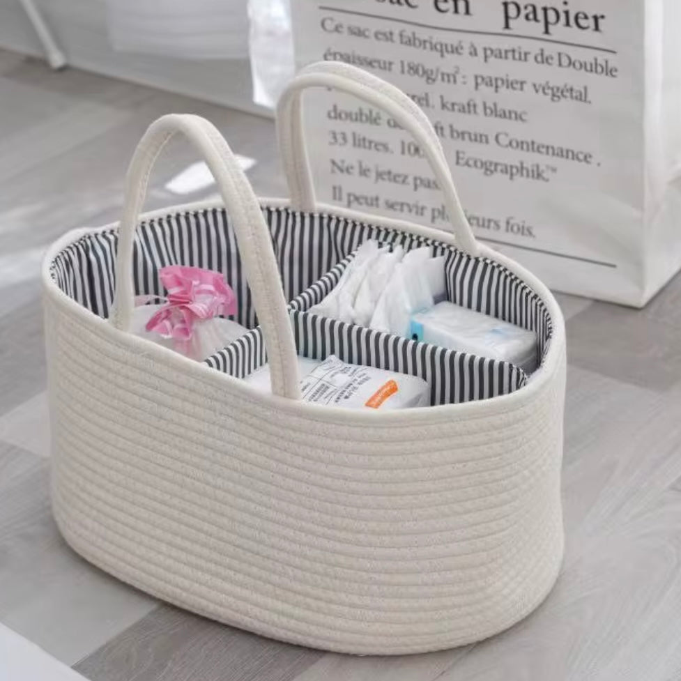White cotton rope nappy caddy with striped lining, filled with nappies, wipes, and bottles, ideal for bedside organisation.