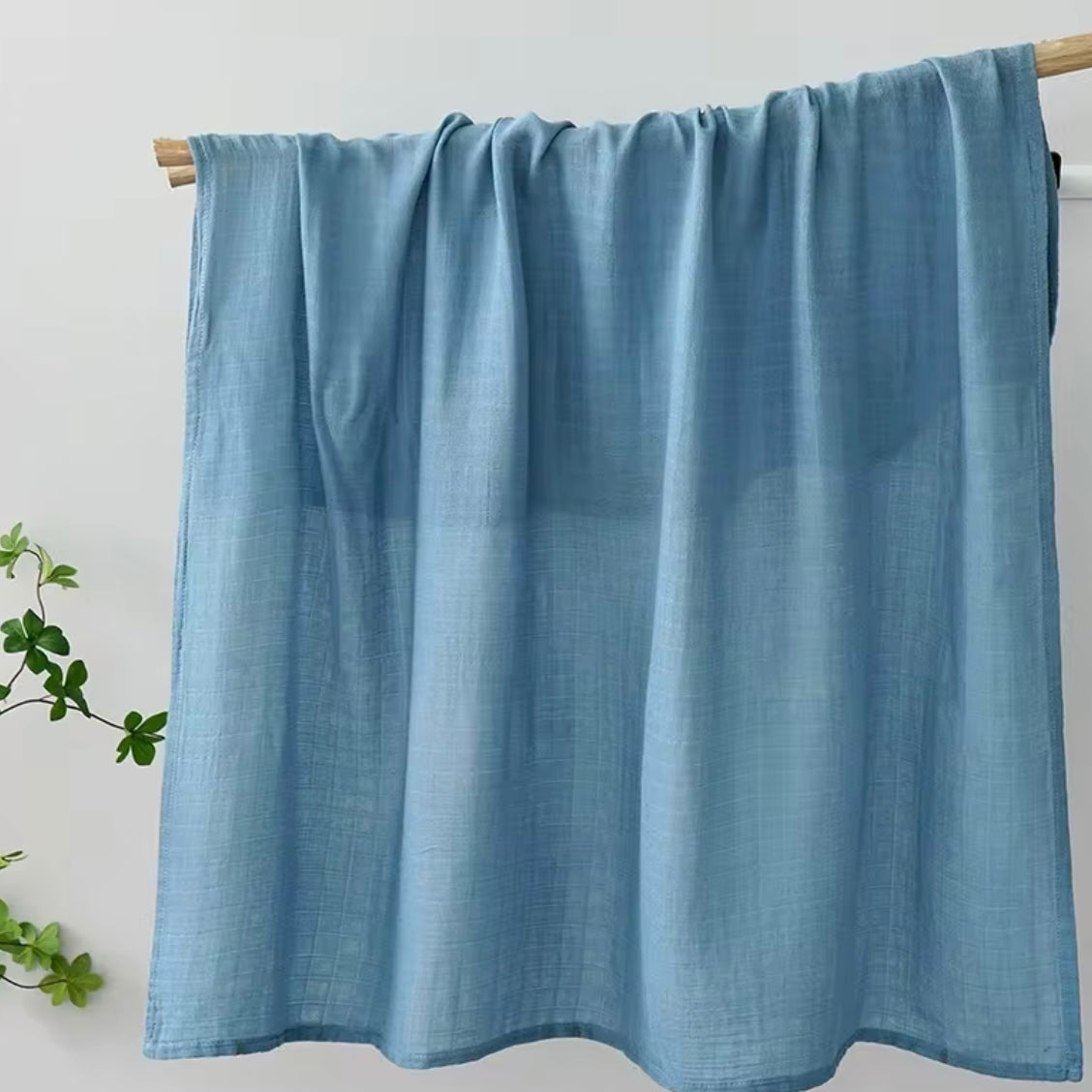 Dusty blue muslin baby wrap, soft and breathable for comfortable swaddling.