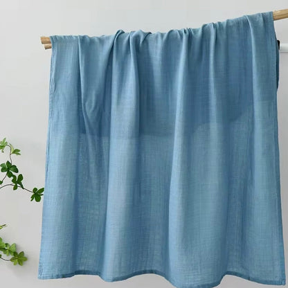 Dusty blue muslin baby wrap, soft and breathable for comfortable swaddling.