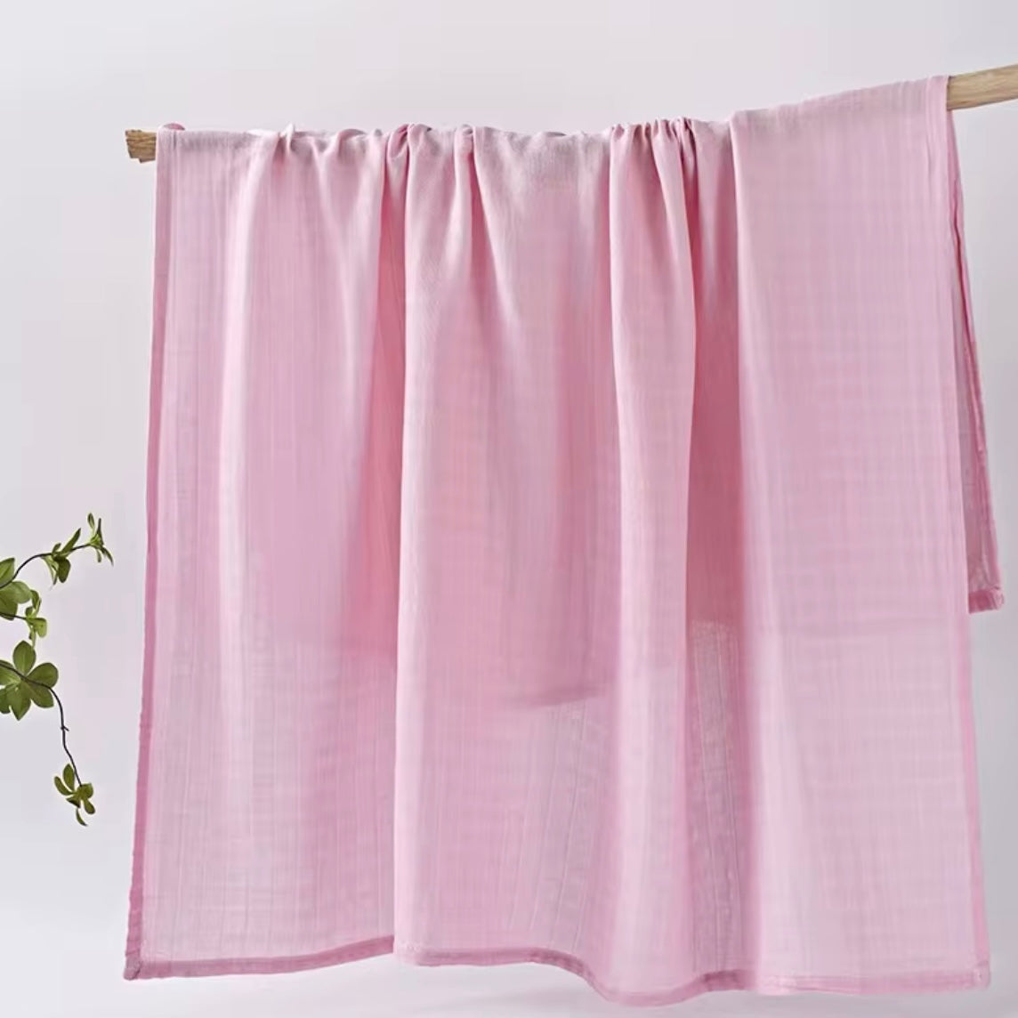 Blush pink muslin baby wrap, soft, breathable, and perfect for baby swaddling.