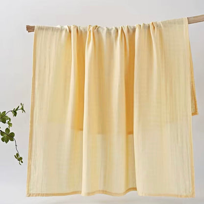 Light yellow muslin baby wrap, soft, breathable, and perfect for newborn swaddling and cuddles.