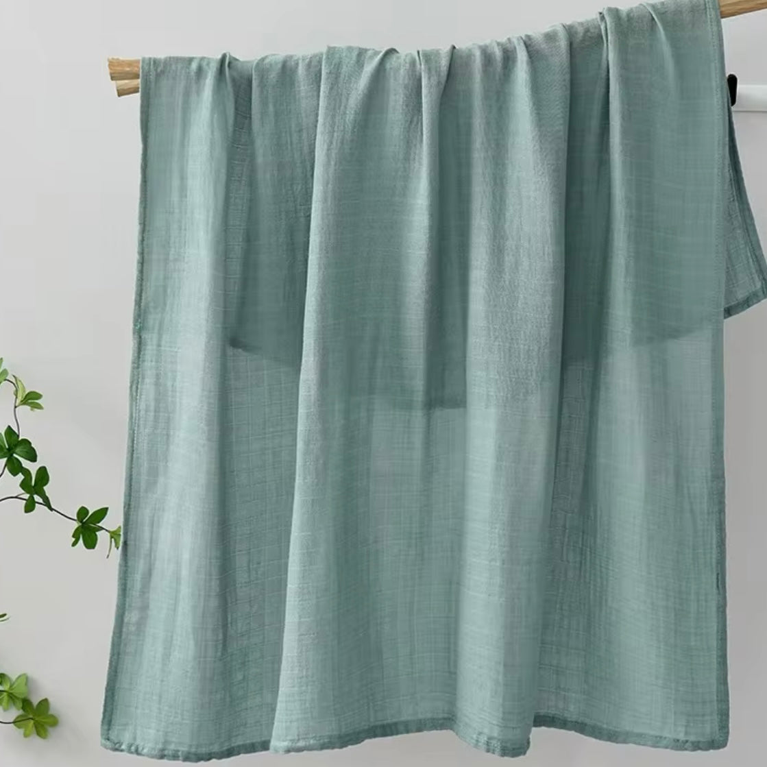 Sage green muslin baby wrap, breathable, versatile, and gentle on baby’s skin.