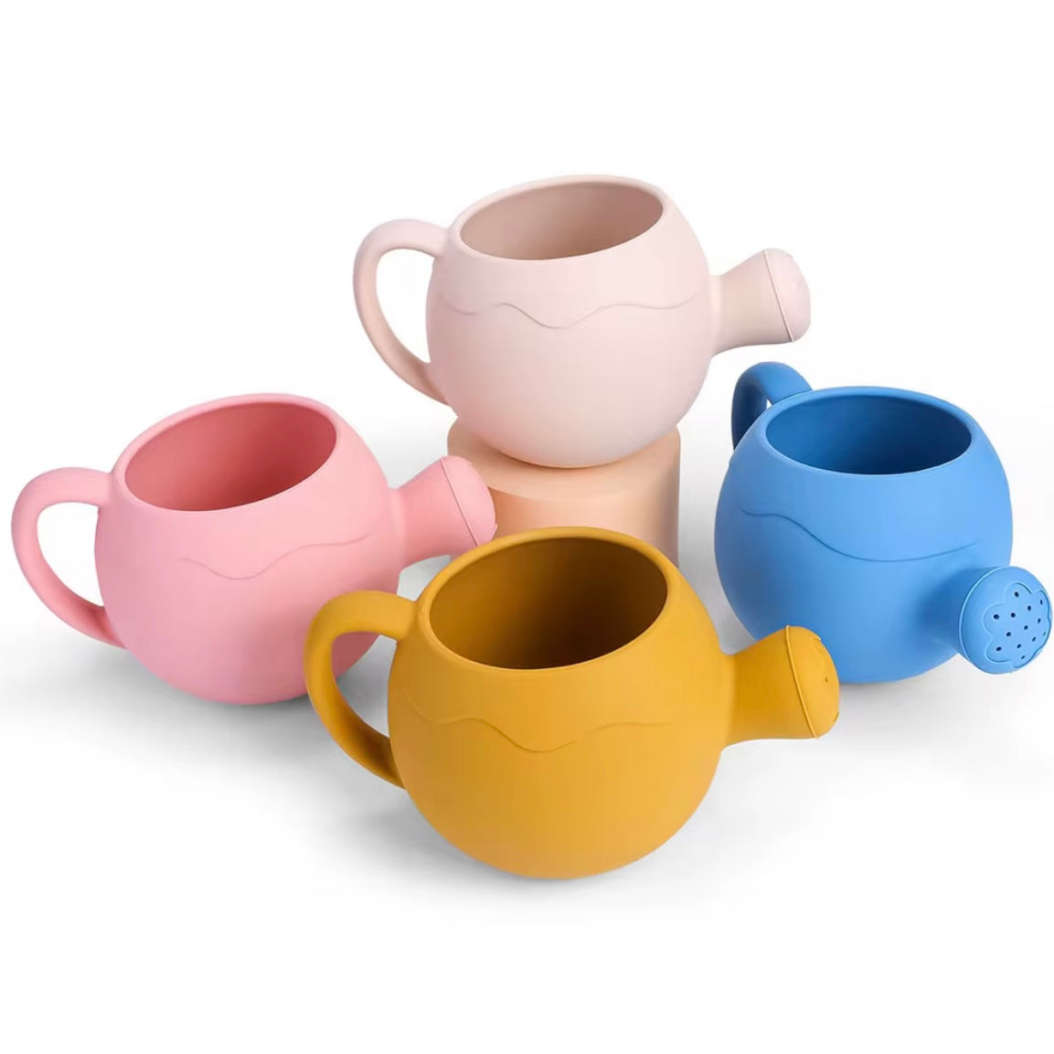 Set of four silicone watering cans in pink, beige, blue, and yellow, perfect for water play and gardening.