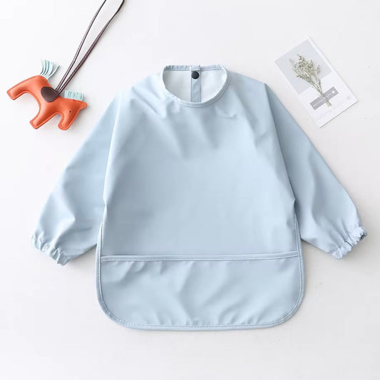 Mess Mate long-sleeved smock bib in pastel blue with waterproof front pocket.