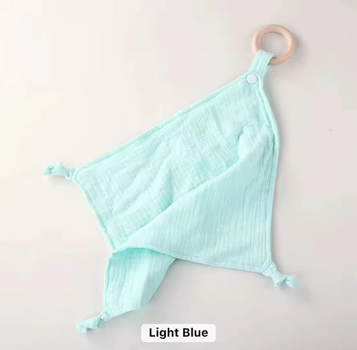 Light blue muslin comforter with natural wooden teether ring, soft and breathable for babies and toddlers.