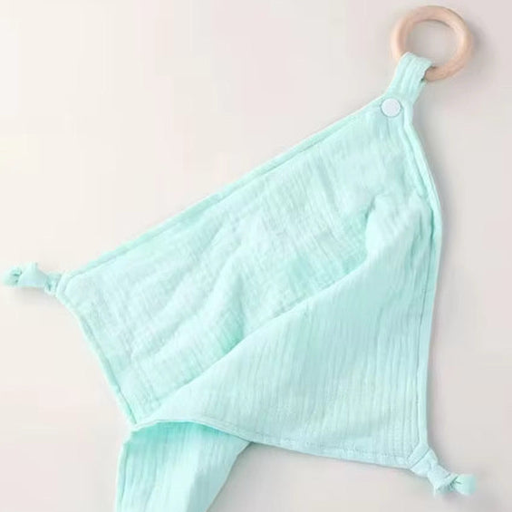Light blue muslin comforter with natural wooden teether ring, soft and breathable for babies and toddlers.