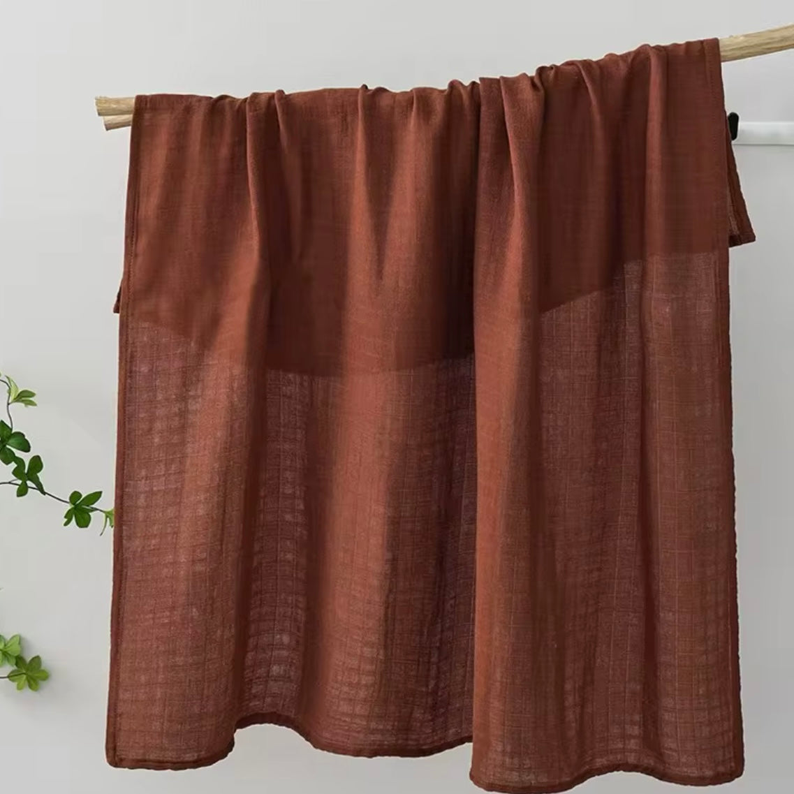 Earthy brown muslin baby wrap, natural and lightweight, gentle for babies.
