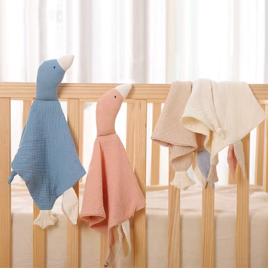 Blue, Pink & Cream on Cot
“Little Honkers muslin goose comforters in blue, pink, and cream hanging on a wooden baby cot.”