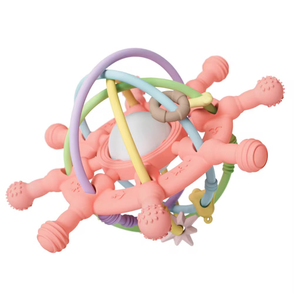 Coral pink silicone teething toy with pastel-colored loops and center rattle ball.
