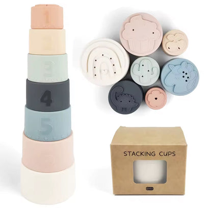 Set of 7 pastel silicone stacking cups with numbers and animal patterns, displayed with packaging box. Perfect for babies and toddlers to develop motor skills and enjoy sensory play.