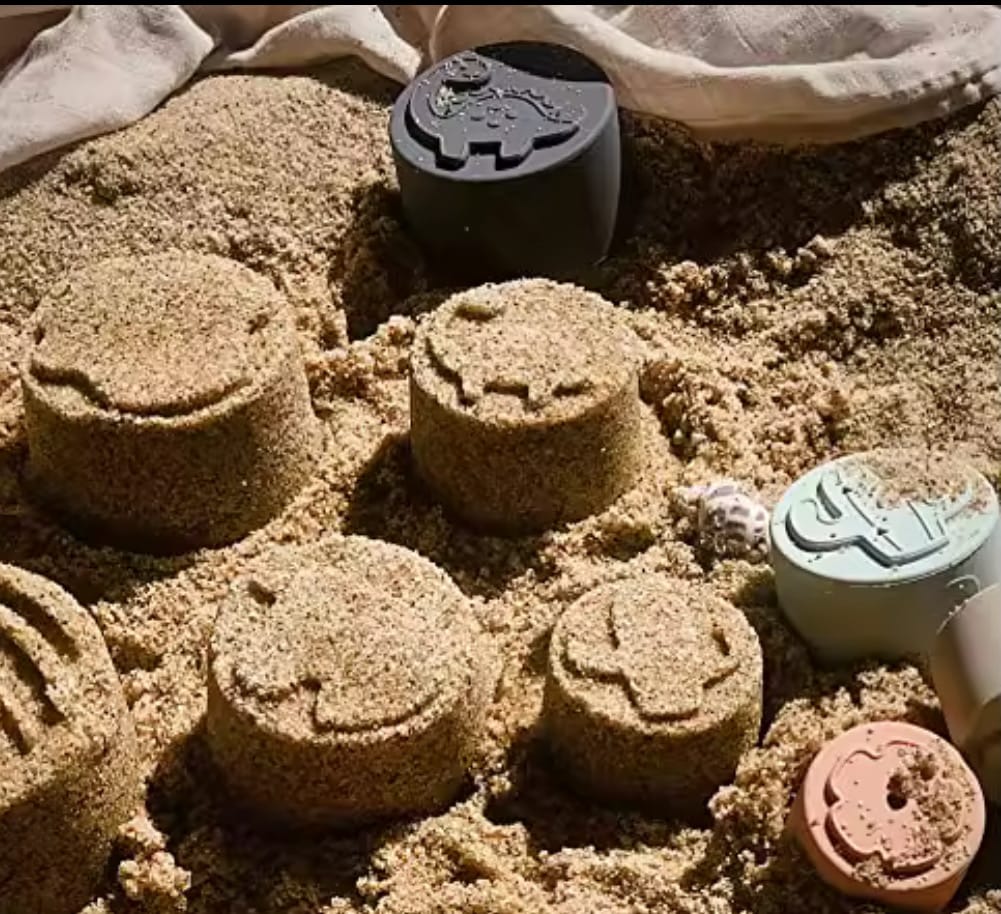 Silicone stacking cups used as beach sand moulds. Features animal-shaped imprints, perfect for creative play, beach fun, and building sensory skills outdoors.