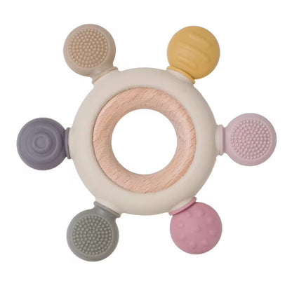Wooden teether wheel with six pastel silicone ends in mustard, pink, grey, and beige tones, each with different sensory textures.