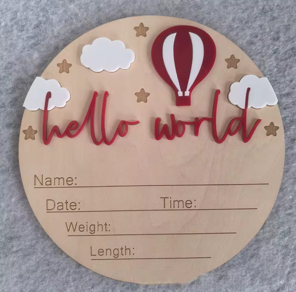 Red hot air balloon hello world plaque – Baby milestone wooden disc with deep red balloon, stars, white clouds, and engraved name/date details.