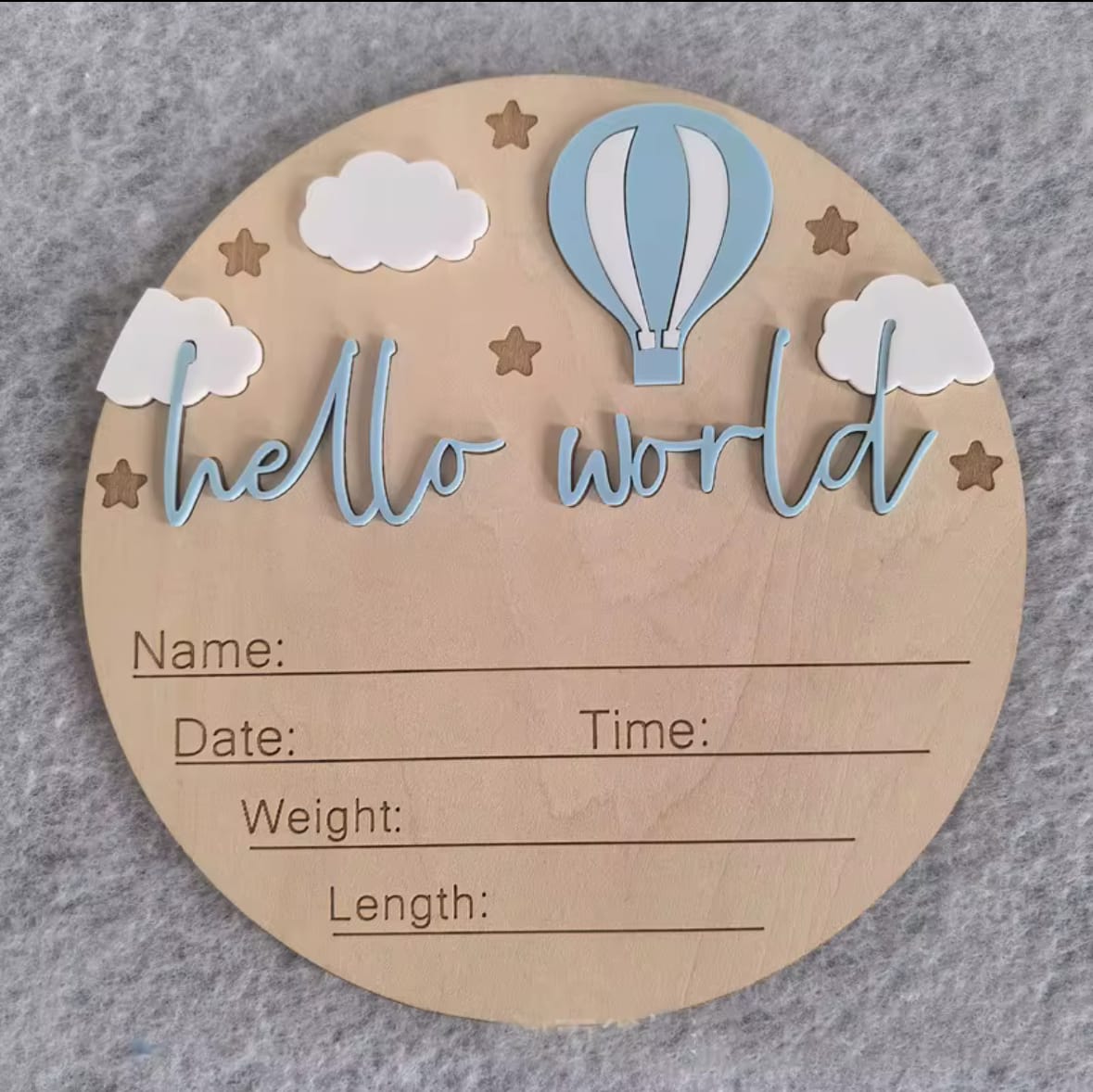 Light blue hot air balloon hello world plaque – Baby announcement milestone disc with pastel blue balloon, stars, clouds, and hello world text.