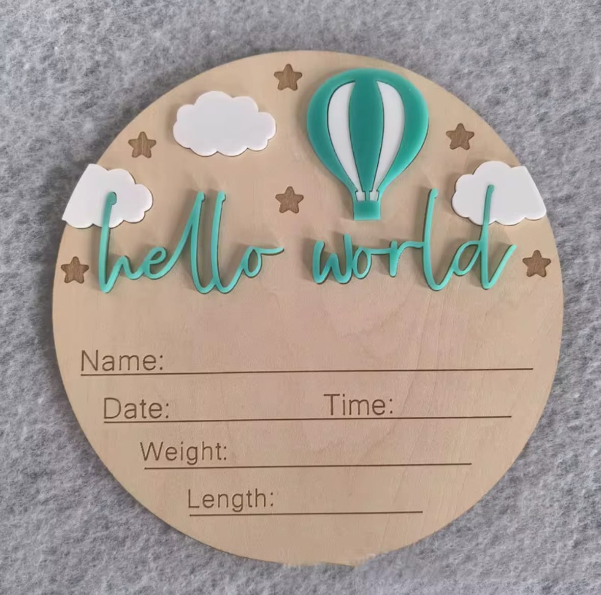 Green hot air balloon hello world plaque – Round wooden baby announcement plaque with teal/green balloon design and “hello world” script.